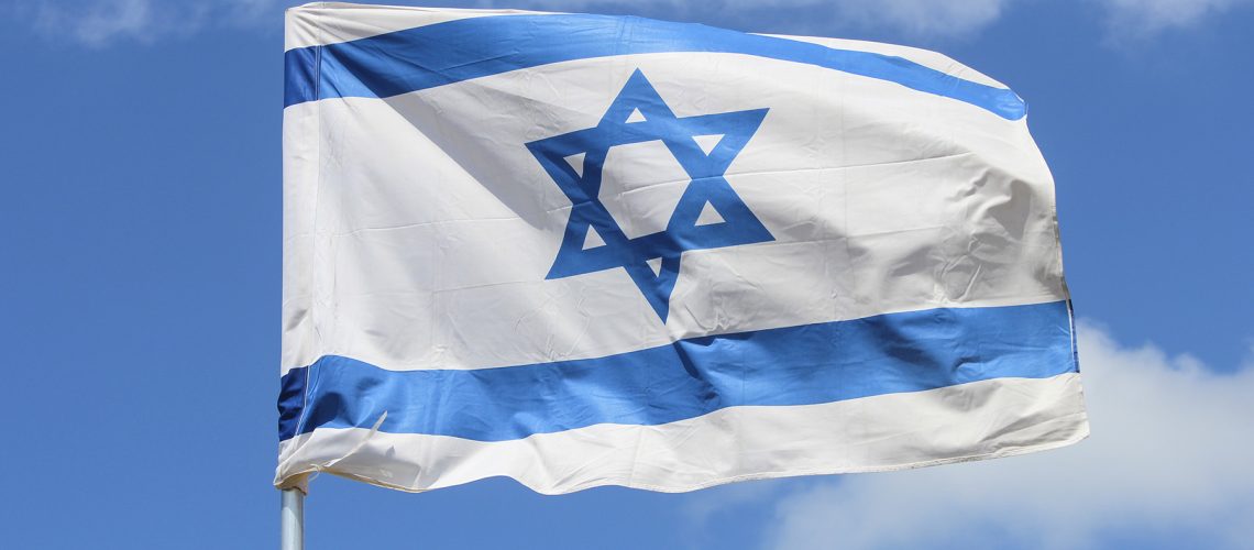 Israeli flag fluttering in the wind against the sky
